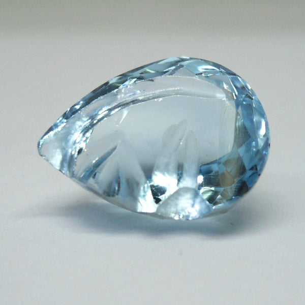 Topacio azul perilla con un rostro tallado