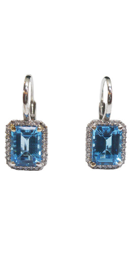 Pendientes de oro blanco de 18 quilates, 750 milésimas, con dos topacios azules talla rectangular, rodeados por una orla de circonitas y con sistema ballestilla de muelle como cierre.